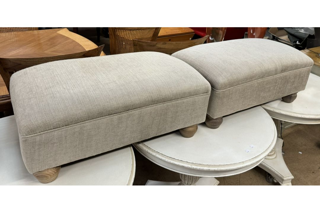 A pair of upholstered footstools on turned legs
