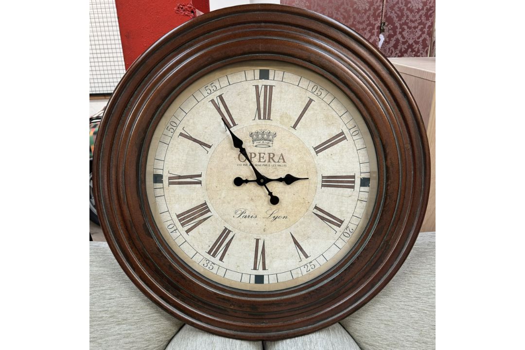 An oversized wall clock with Roman numerals