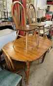 A pine dining table together with a set of four Ercol stick back dining chairs