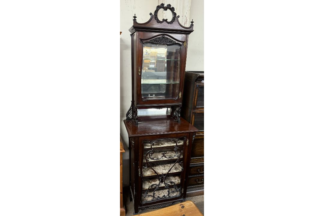 An Edwardian mahogany chiffonier with a carved cornice above a bevelled glazed door,