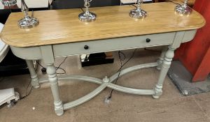 A side table with a rectangular rounded top above a single drawers on turned legs and an X framed