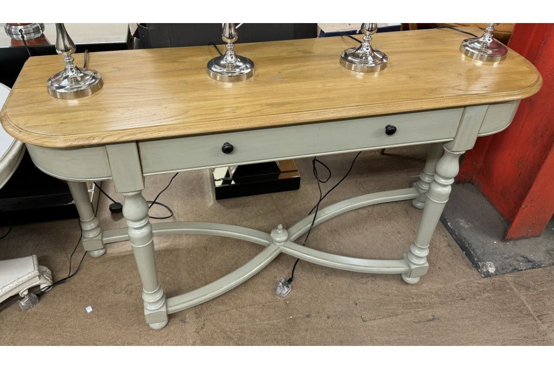 A side table with a rectangular rounded top above a single drawers on turned legs and an X framed