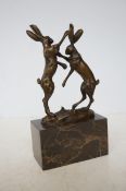 Bronze fighting hares on marble base