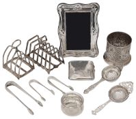 A collection of silver to include a bottle holder and toast racks