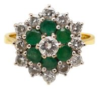 An emerald and diamond cluster ring