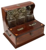 An Edwardian Sheraton Revival mahogany three bottle Tantalus