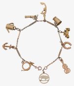 A 9ct charm bracelet including a carriage, golf clubs French horn and gondola