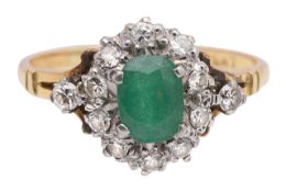 An emerald and diamond cluster ring