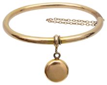 An oval bangle with suspended locket