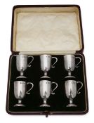 A cased set of six Edwardian silver spirit tots