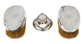 An Edwardian silver capstan inkwell and pair of silver backed clothes brushes