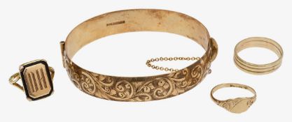 Four gold items including a stiff bangle and three rings