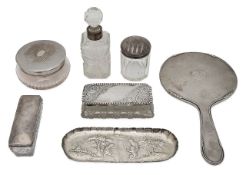 A silver hand mirror, a pin tray and various silver lidded dressing table jars