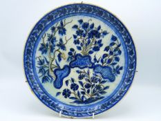 A 17thC. rimless Turkish Ottoman Iznik pottery dish with decorative floral sprays & footed base, fir