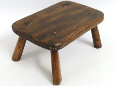 A small oak milking stool, 260mm wide x 190mm deep