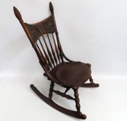 An early 20thC. spindle rocking chair, brass label