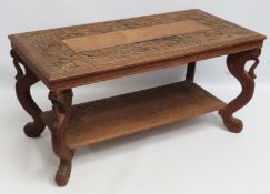 An Asian teak coffee table with carved fish for le