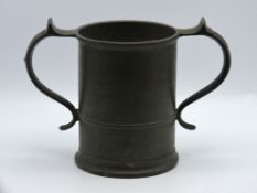 A two handled pewter tankard, somewhat indistinct