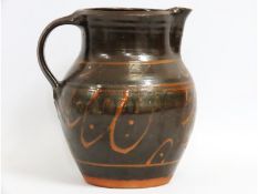 A large studio pottery slip ware jug, indistinct m