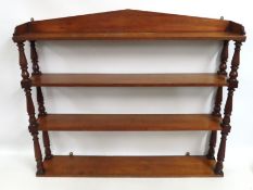 A wall mounted mahogany bookshelf, 1065mm wide x 8