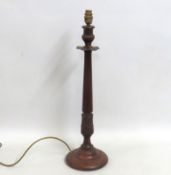 A decorative carved wooden lamp base with fluted s
