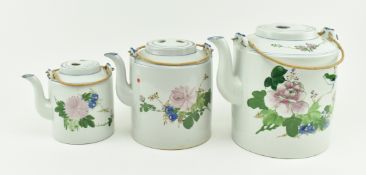 THREE 20TH CENTURY GRADUATING CERAMIC TWIN HANDLE TEAPOTS