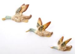 BESWICK STYLE COLLECTION OF THREE GRADUATING DUCK FIGURES
