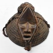 AFRICAN TRIBAL HAT DECORATED WITH TWO WOODEN CARVED MASKS