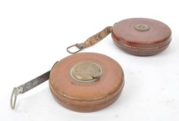 SET OF TWO 1960S LEATHER CASED SURVEYOR TAPE MEASURES