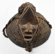 AFRICAN TRIBAL HAT DECORATED WITH TWO WOODEN CARVED MASKS