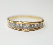 A modern 18ct gold and graduated nine stone princess cut diamond set half hoop ring, size L, gross