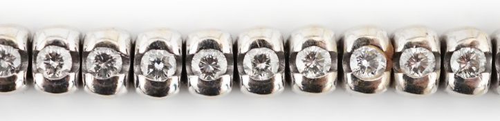 A modern 18ct white gold and collet set forty seven stone round brilliant cut diamond set line