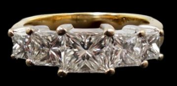 A modern 18ct gold and graduated five stone princess cut diamond set half hoop ring, the central