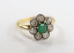 An 18ct, emerald and diamond set circular cluster ring, size L, gross weight 3.3 grams.