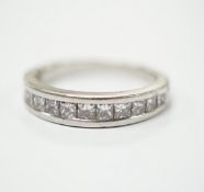 A white metal (engraved PT 950) and channel set twelve stone diamond half eternity ring, size N/O,