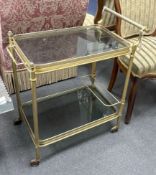 A Maison Jansen style gilt metal and smoked glass two tier trolley, width 64cm, depth 41cm, height
