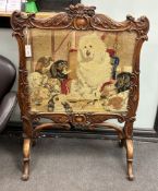 A Victorian carved walnut firescreen, worked with a scene after Landseer, width 84cm, height