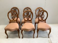 A set of six Victorian carved walnut balloon back dining chairs