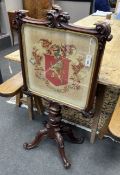 A Victorian carved mahogany firescreen, worked with armorial crest, width 64cm, height