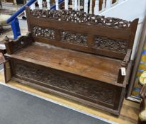 An Indonesian carved hardwood box seat settle, width 56cm, depth 56cm, height 98cm