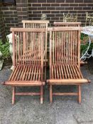 A set of four weathered teak folding garden chairs