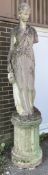 A large reconstituted stone female water carrier garden statue on circular fluted plinth, height