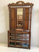 A late Victorian oak hallstand with cast brass elephant head hooks, width 115cm, height 210cm.