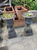 A pair of Victorian style circular black painted cast iron campana urns on stands, diameter 38cm,