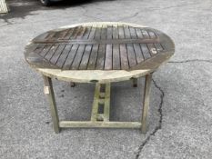 A Westminster circular weathered teak extending garden table, (leaf not functioning correctly),