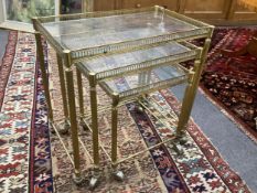 A nest of three mid century brass and glass tea tables, width 52cm, depth 32cm, height 52cm.