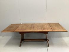 An oak draw leaf dining table, the shaped end standards united by flat stretcher, width 130cm, depth