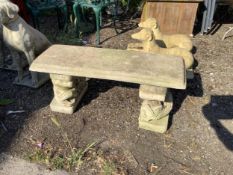 A reconstituted stone garden bench with cast carp supports, width 99cm, depth 36cm, height 40cm.
