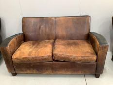 A leather settee, width 156cm, depth 78cm, height 82cm and a pair of leather wing armchairs.