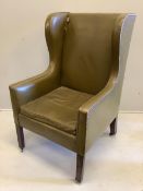 A George III wing armchair with olive leather upholstery, width 70cm, depth 70cm, height 115cm.
